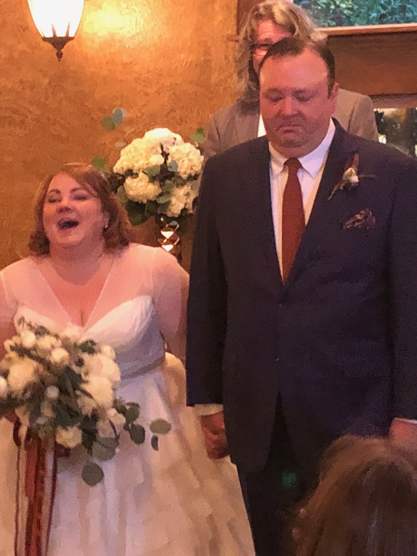 Amy and Daniel on their wedding day — Amy in white with her bouquet.
