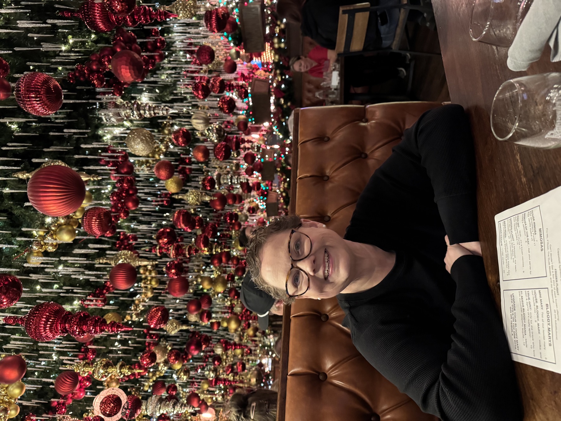 Amy beaming in front of a glittering red-and-gold Christmas display.
