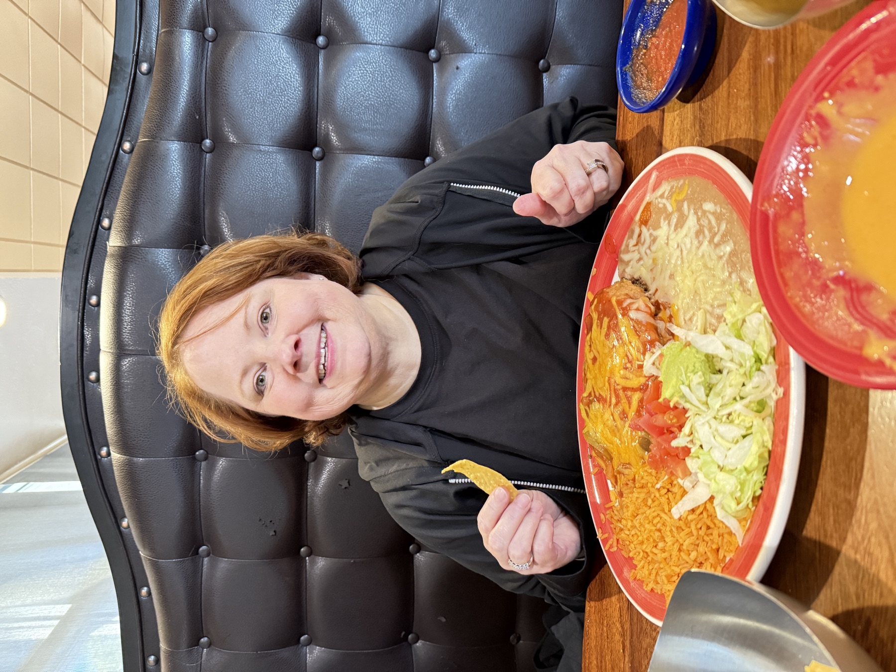 Amy at a favorite Mexican spot, a tortilla chip in hand.