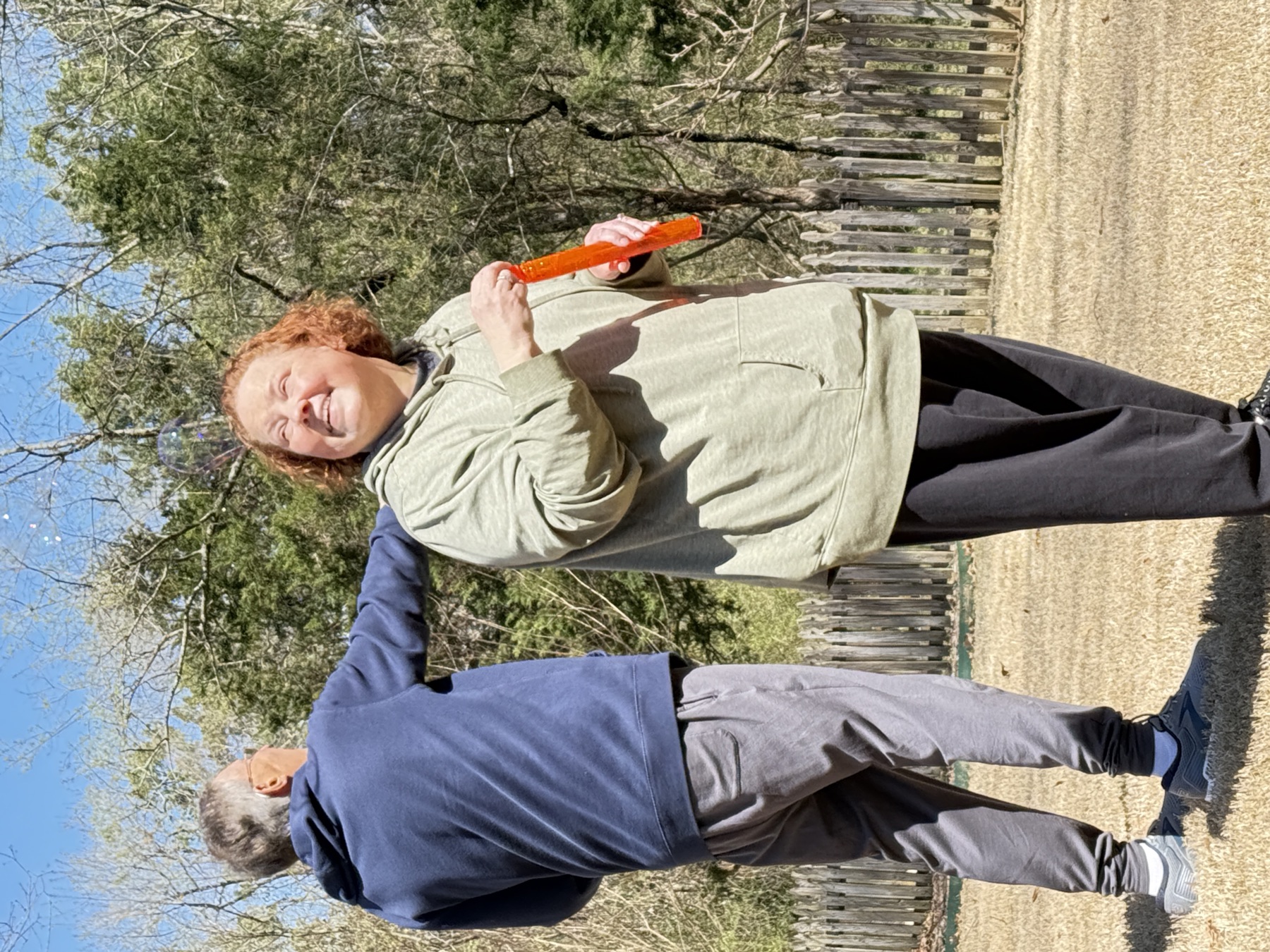 Amy laughing on a sunny walk outdoors, an orange popsicle in hand.
