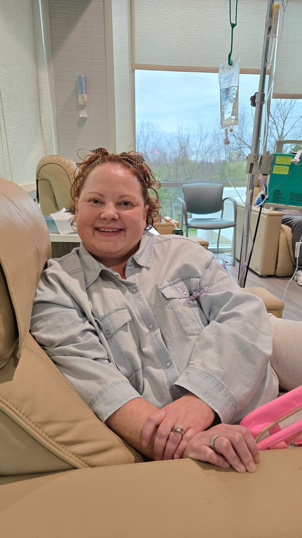 Amy smiling brightly during a chemotherapy infusion.