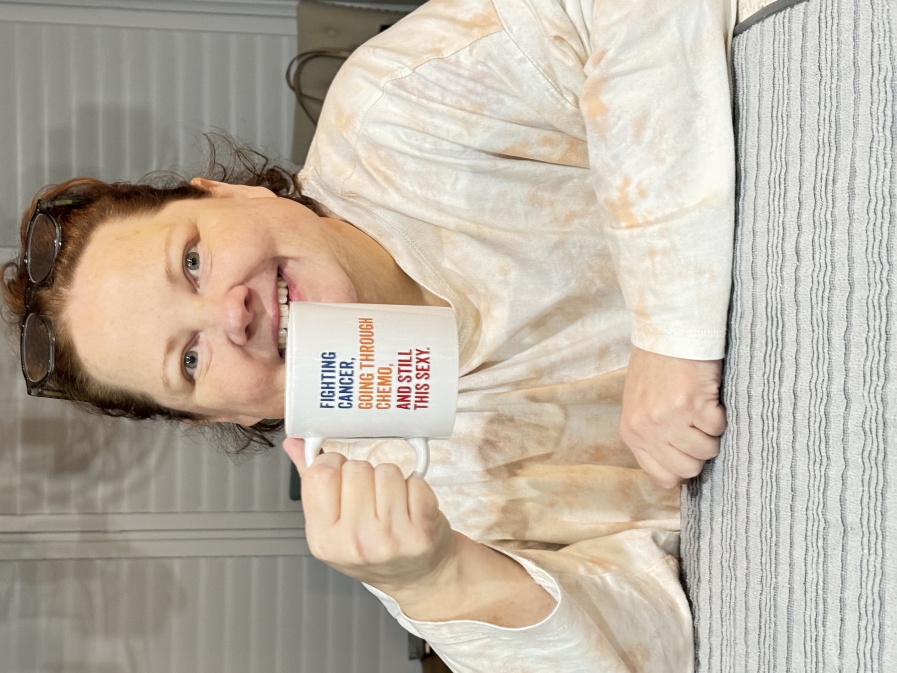 Amy holding her 'Fighting cancer, going through chemo, and still this sexy' mug.